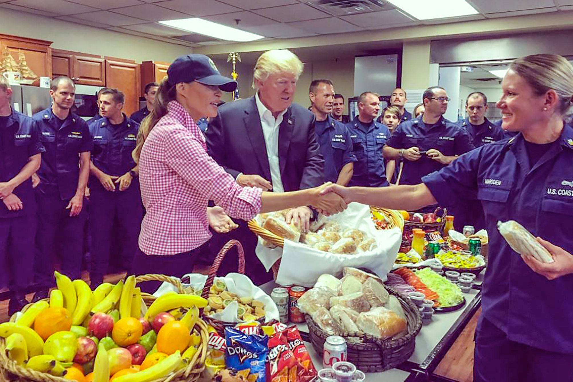 President Donald J. Trump looks on as First Lady Melania Trump shakes hands with a member of the Coast Guard during a Thanksgiving day visit to the Coast Guard station in Riviera Beach, Fla., Nov. 23, 2017.