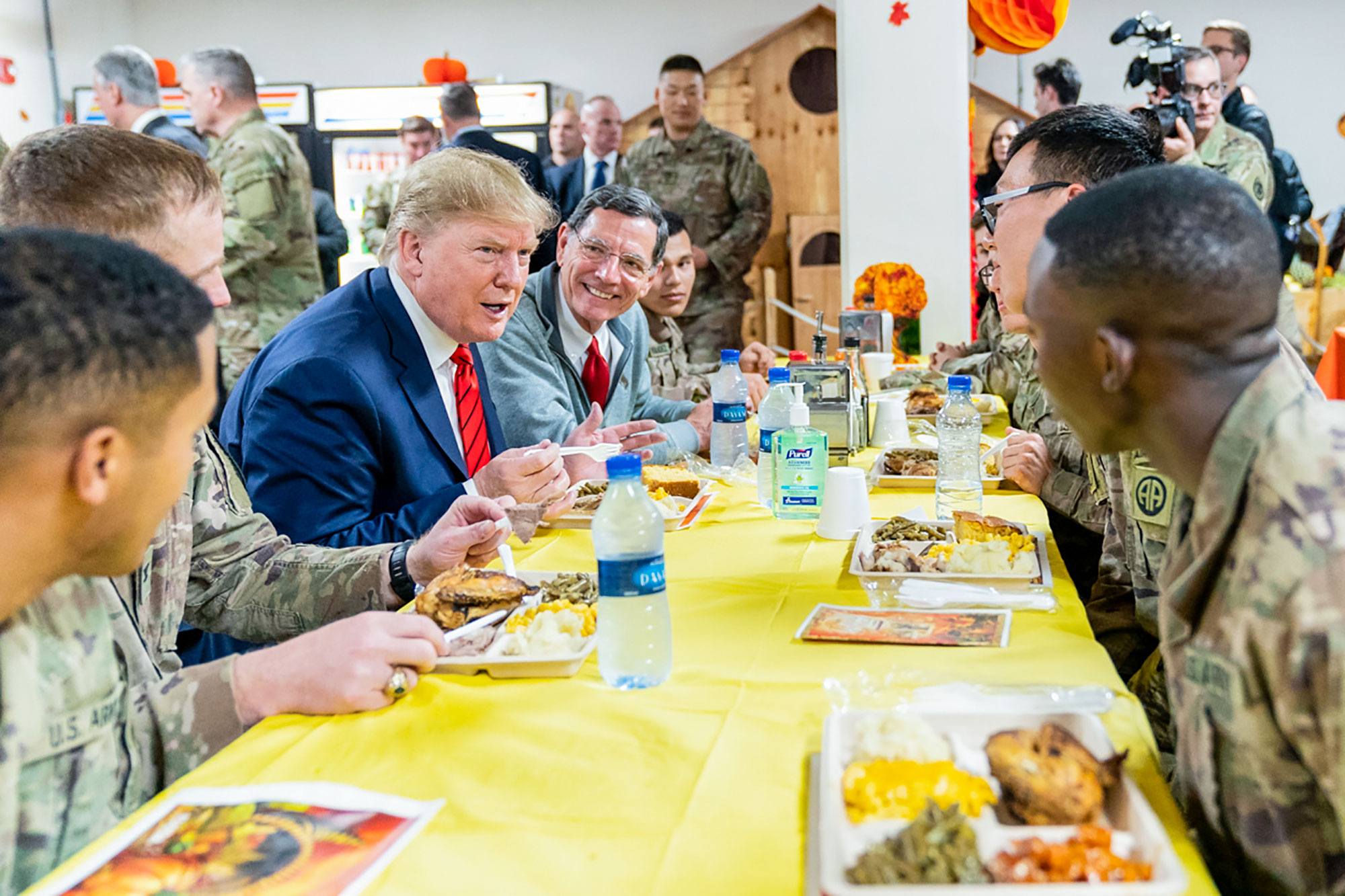 President Donald J. Trump, joined by Senator John Barrasso, R-Wy, sits with US troops Thursday, November 28, 2019, at Bagram Air Base, Afghanistan, during a surprise Thanksgiving meal.